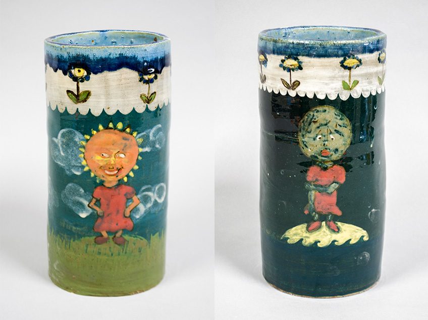 Wheel thrown cylinder image includes front with decorated images of a sun character on one, and moon character on the other. The one with the sun contains bright colors, and the moon with dark colors.