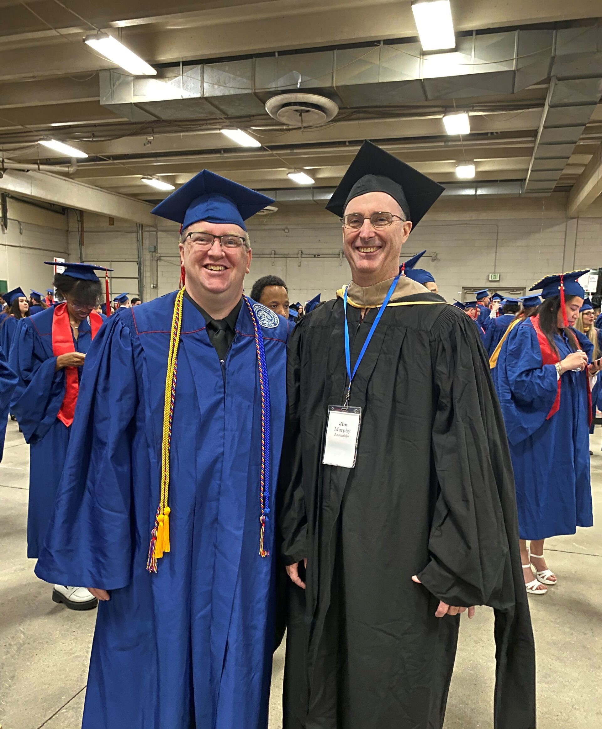 Spring 2024 Commencement - faculty (Jim) and graduating undergraduate accounting student (Tim Cloran) in regalia as they wait to line up