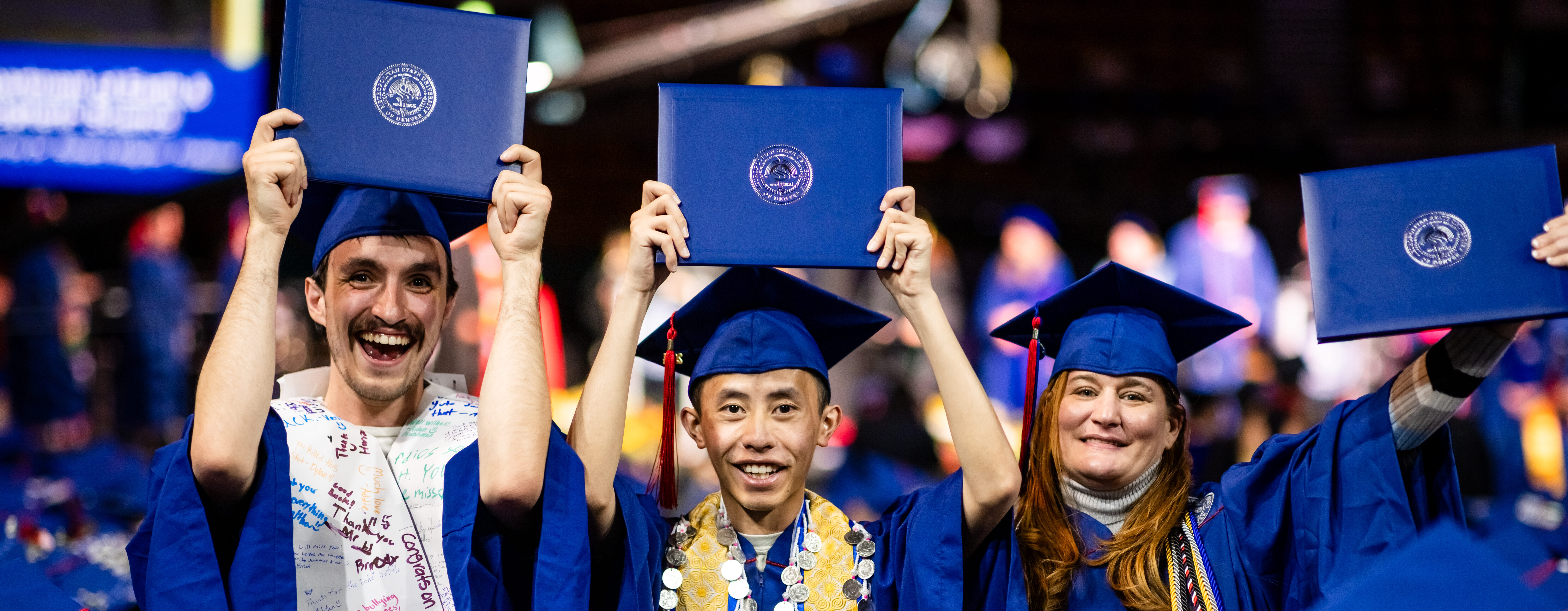 A group of graduates celebrate by holing up their diploma covers