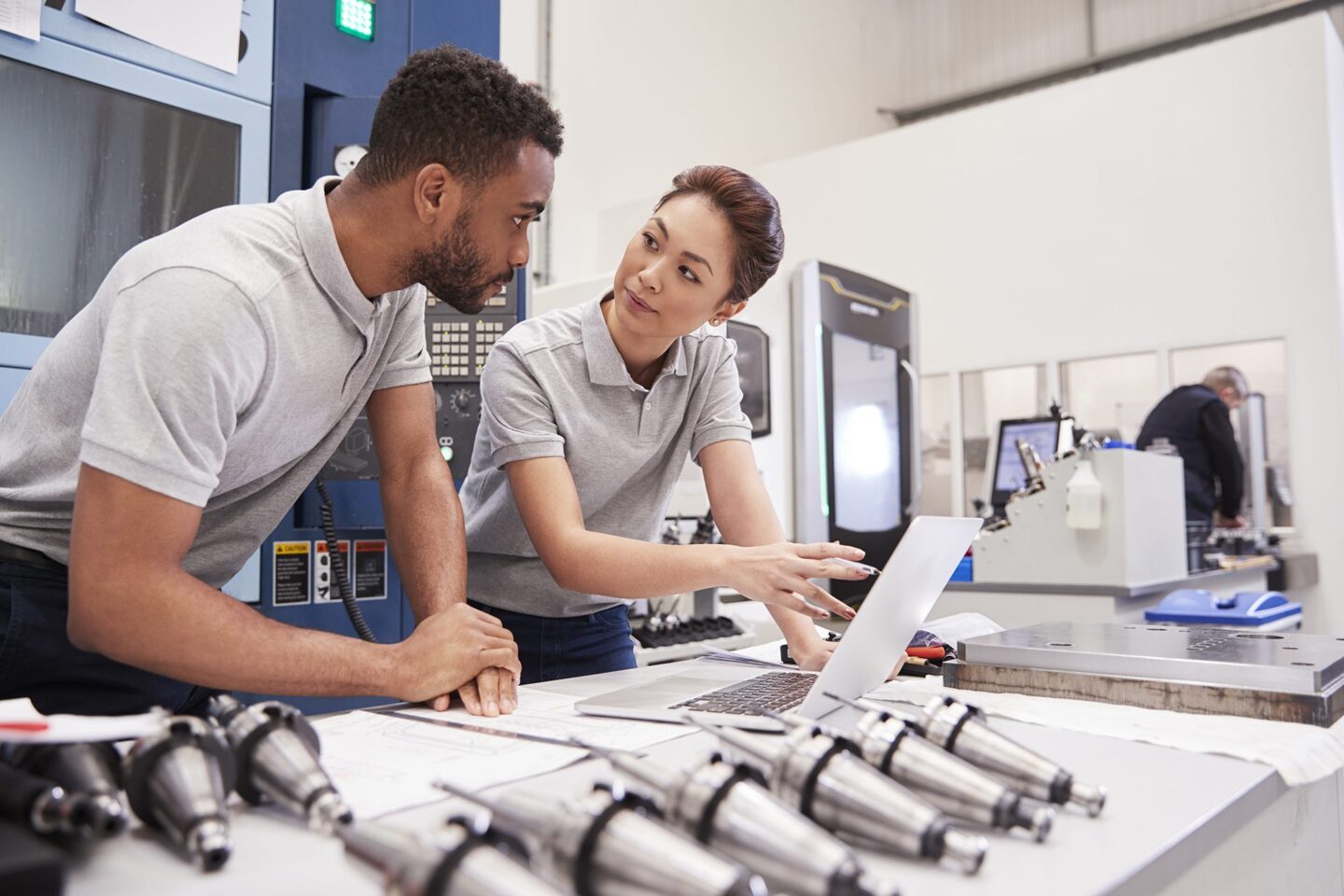 Two Engineers Using CAD Programming Software On Laptop