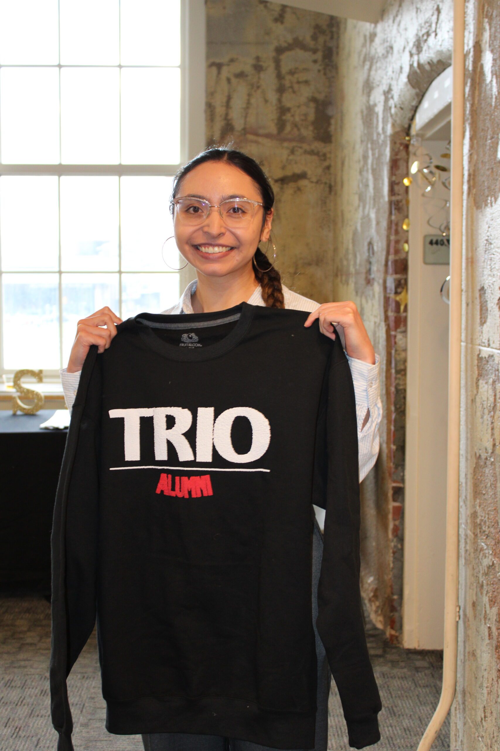TRIO graduate with black TRIO sweatshirt
