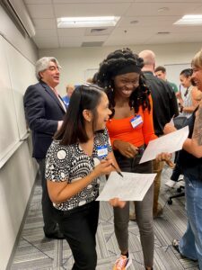 Fall 2024 MPAcc Orientation - attendees laughing as they are filling out a bingo networking sheet
