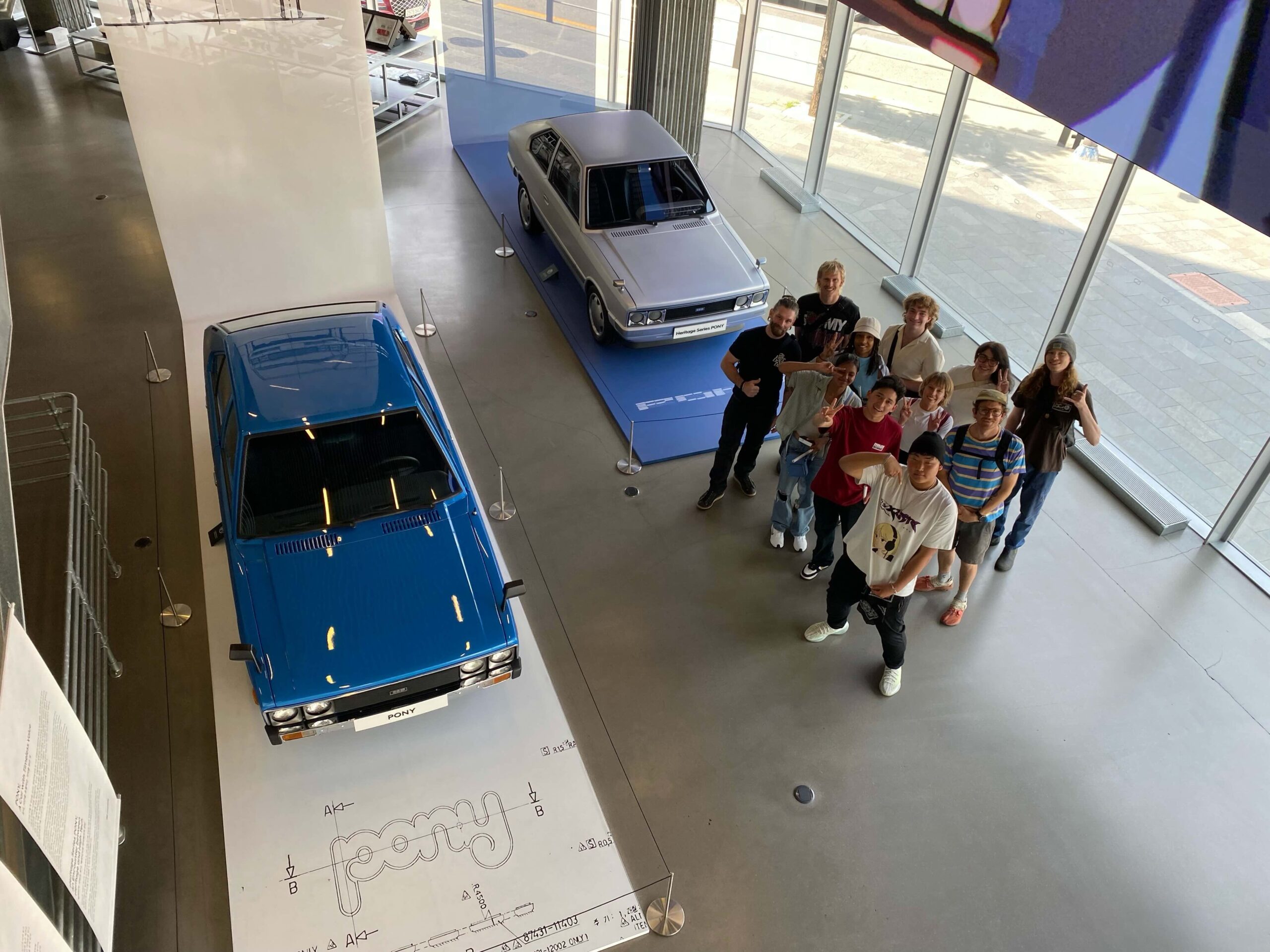 Students standing next to museum cars at the Hyundai Design Center, in Seoul, South Korea