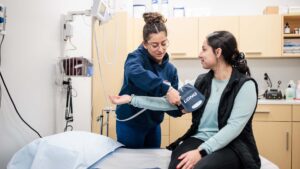 Julianna Montoya taking a patient's blood pressure