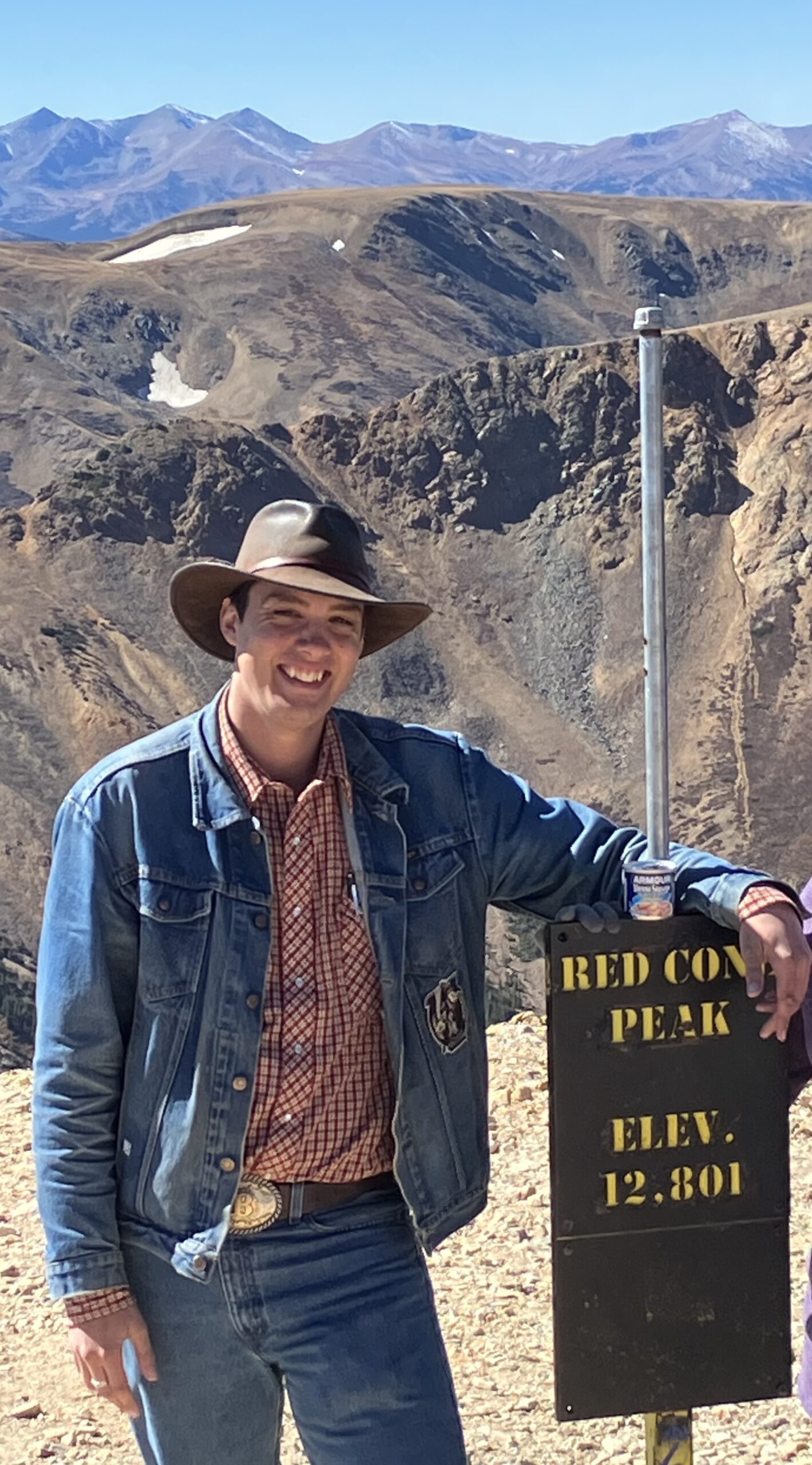 Ben Brown smiling on top of a mountain.