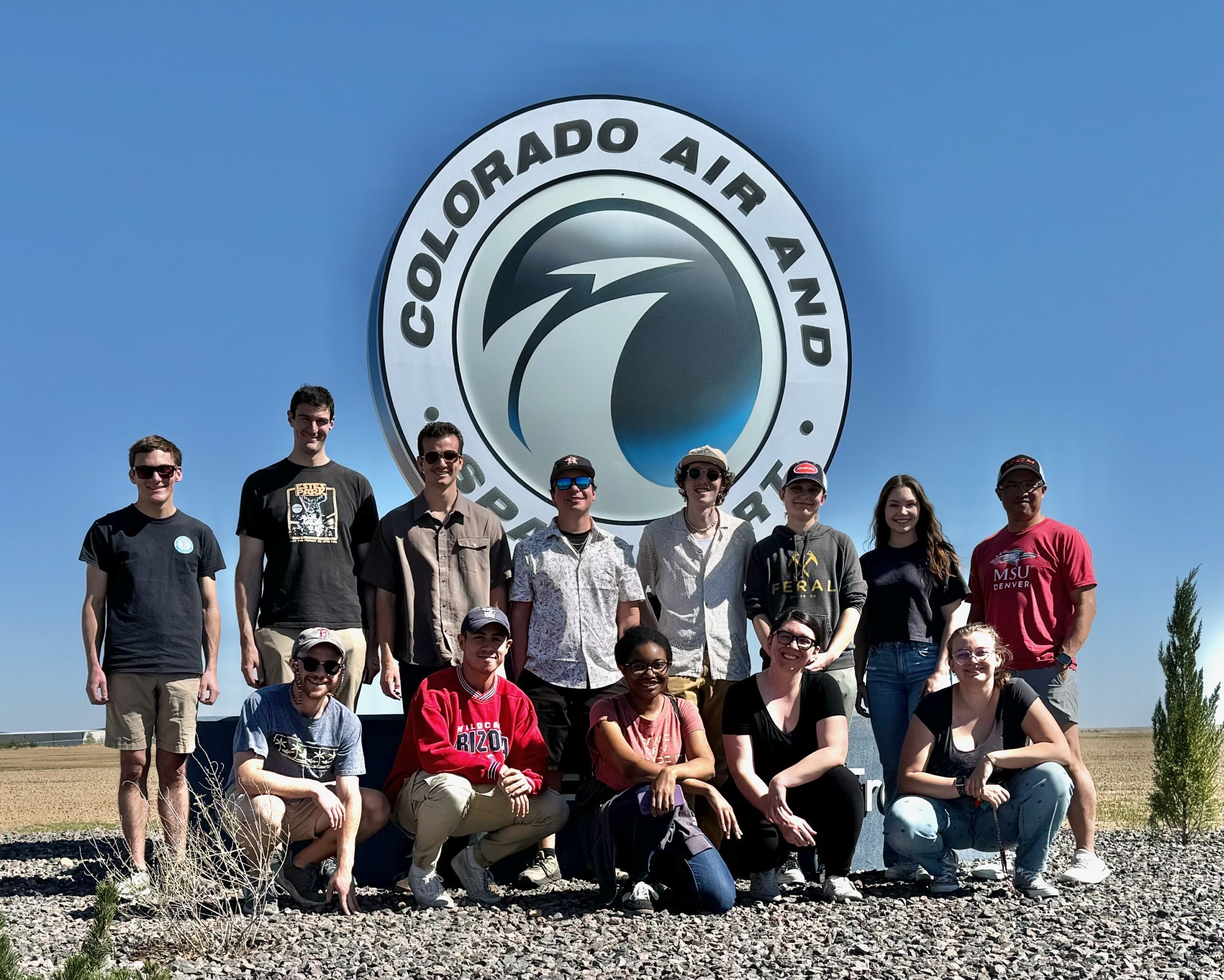 Students and professor pose for a picture in front of the radar site sign.