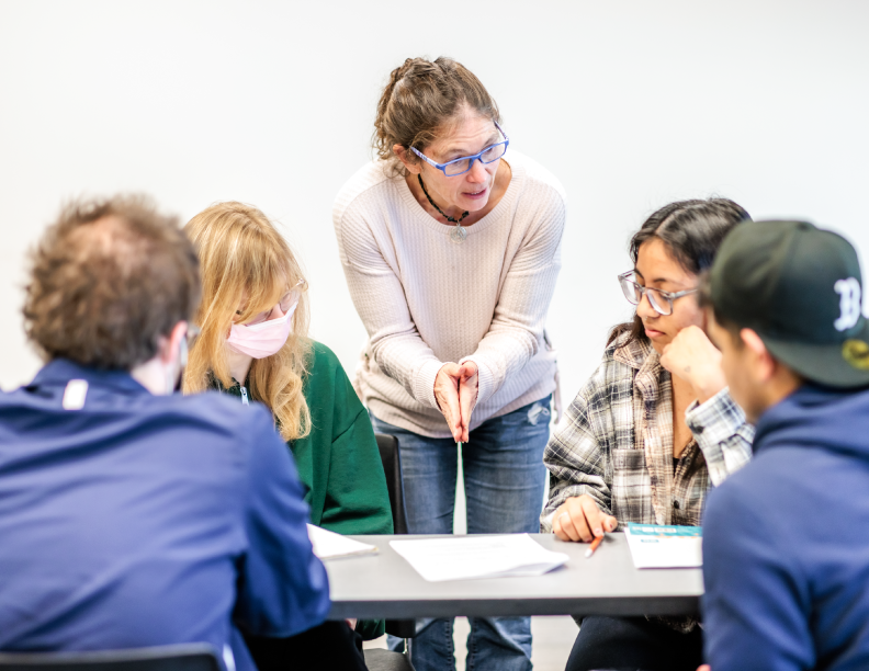 Faculty member interacting with four students in an MSU Denver Science classroom