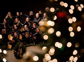 Choir singing behind twinkle lights