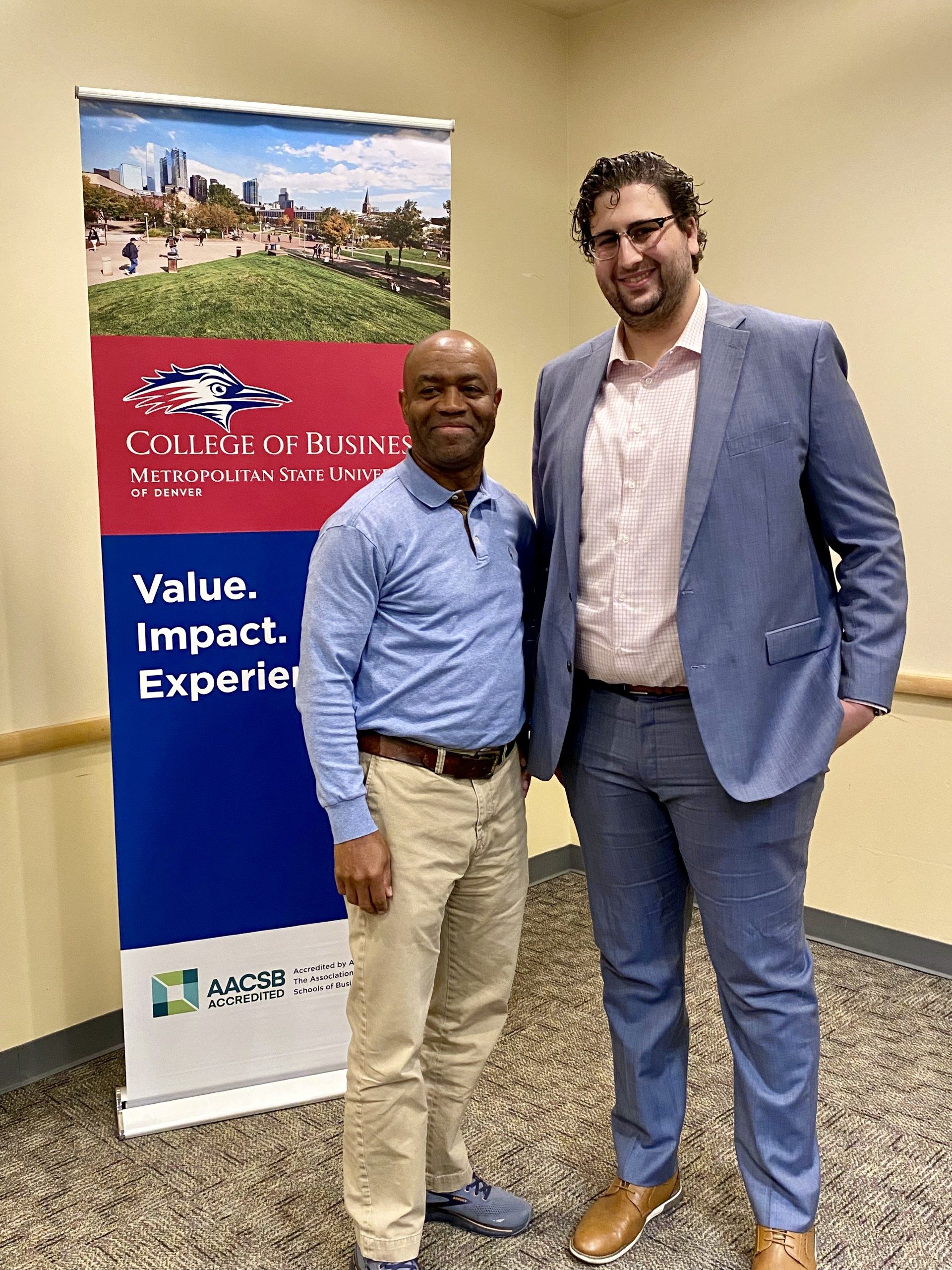 CBUS Outstanding Student Awards Fall 24 - Jason LaBau (UG accounting recipient) & Greg Clifton (acc department chair) posing in front of a CBUS sign