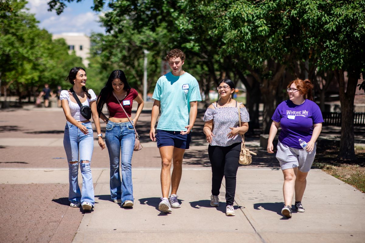 Five students walk and smile on Auraria campus