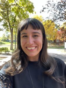 Woman, Mariah Master, Smiling in a black shirt. Background a picture of a park.