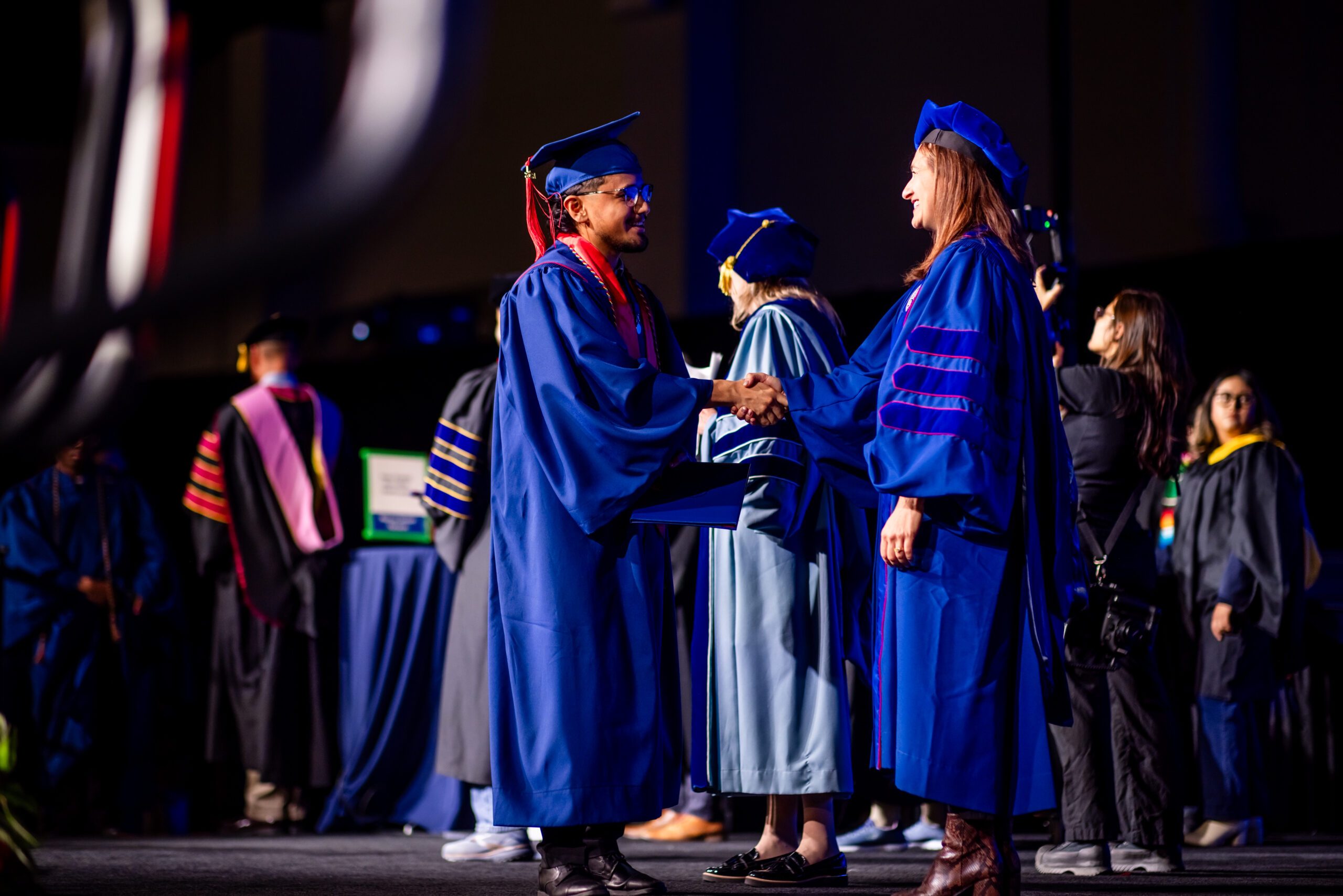 accounting graduate shaking leader's hand on graduation stage