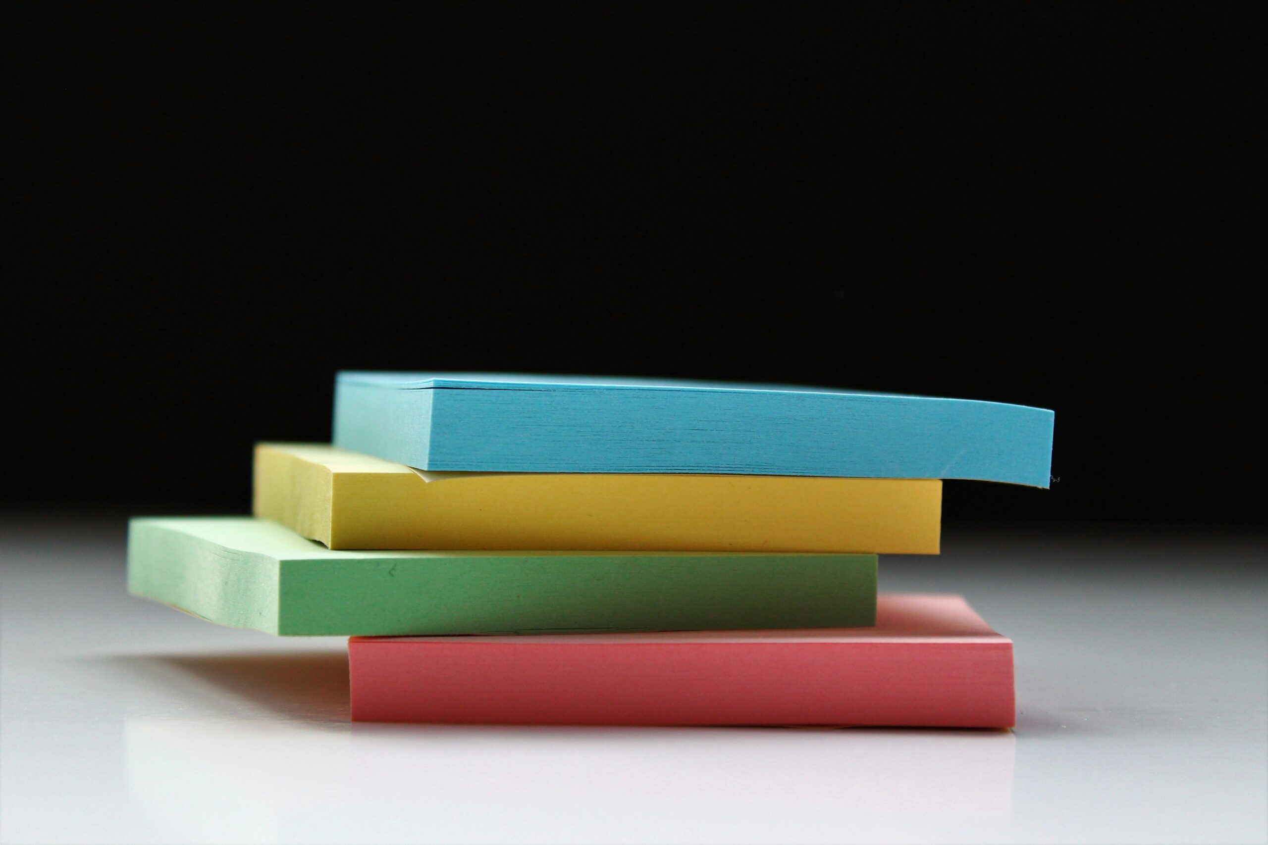 Stack of multi colored post it notes on a half black and white background