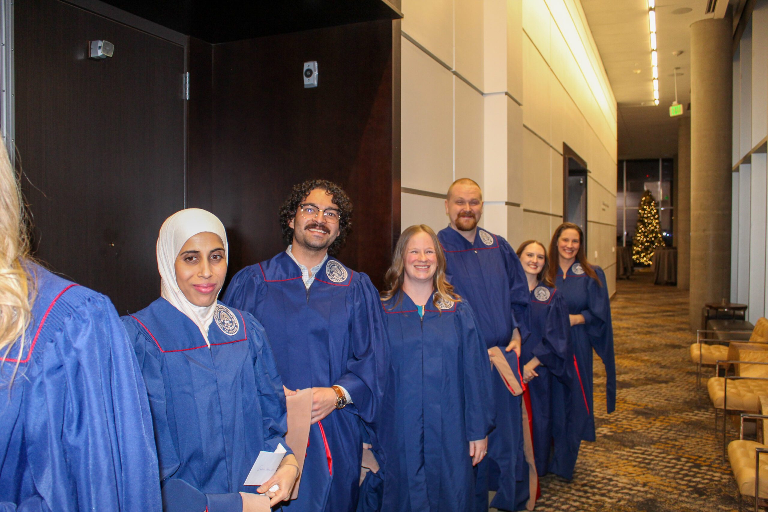MPAcc graduates lining up in regalia -Fall '24 MBa & MPAcc Hooding Celebration