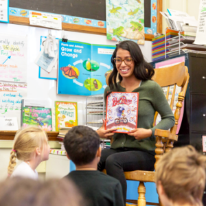 Photo of Idalee Nunez reading to a group of young children in a classroom.