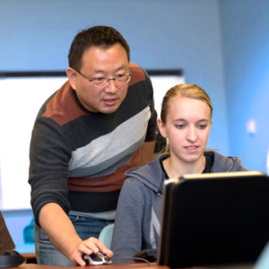 Photo of Dr. Yeh helping a student in the computer lab.