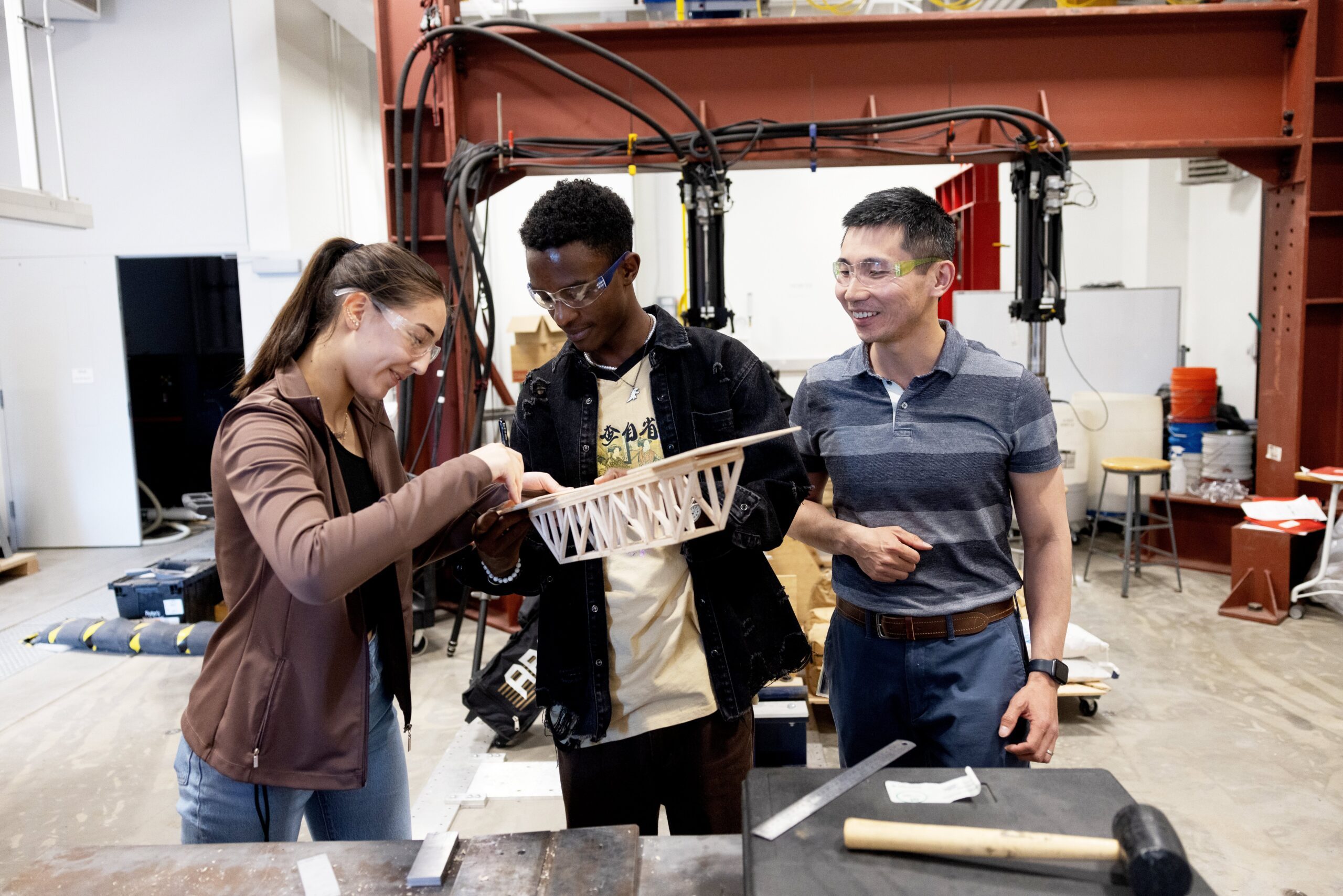 two mechanical engineering students with faculty member in introduction to mechanical engineering class