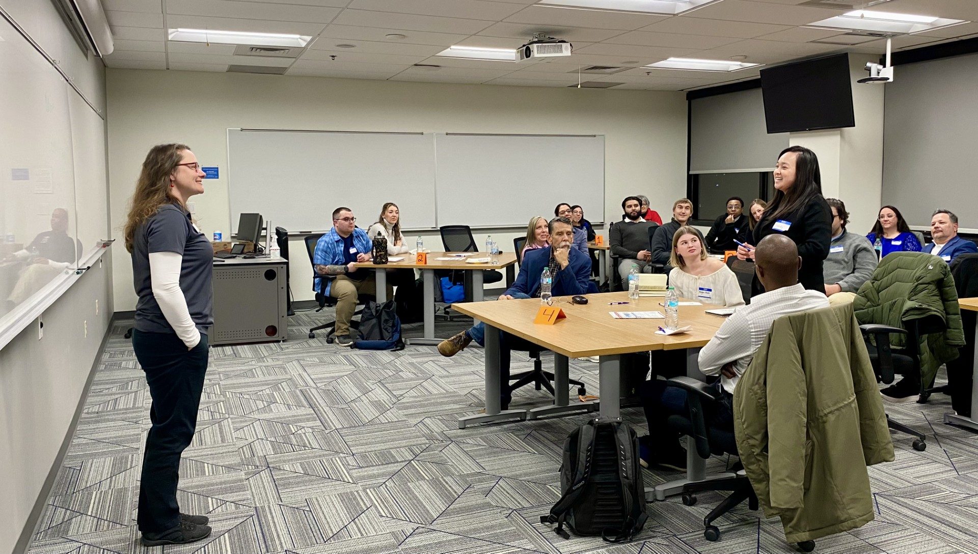 MPAcc faculty, Letitia, leading student intros as a student stands up amongst seated orientation attendees to introduce herself (Sandy)