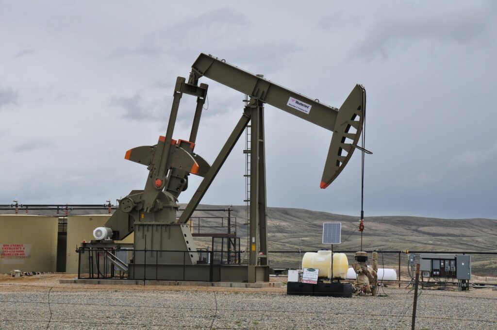 An image of an oil rig operating in an open field