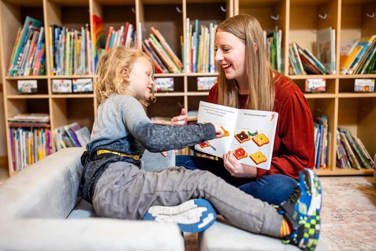MSU Denver’s Abby Marroon works on articulation with Monty Manley, 4, while reading a book at the Auraria Early Learning Center.