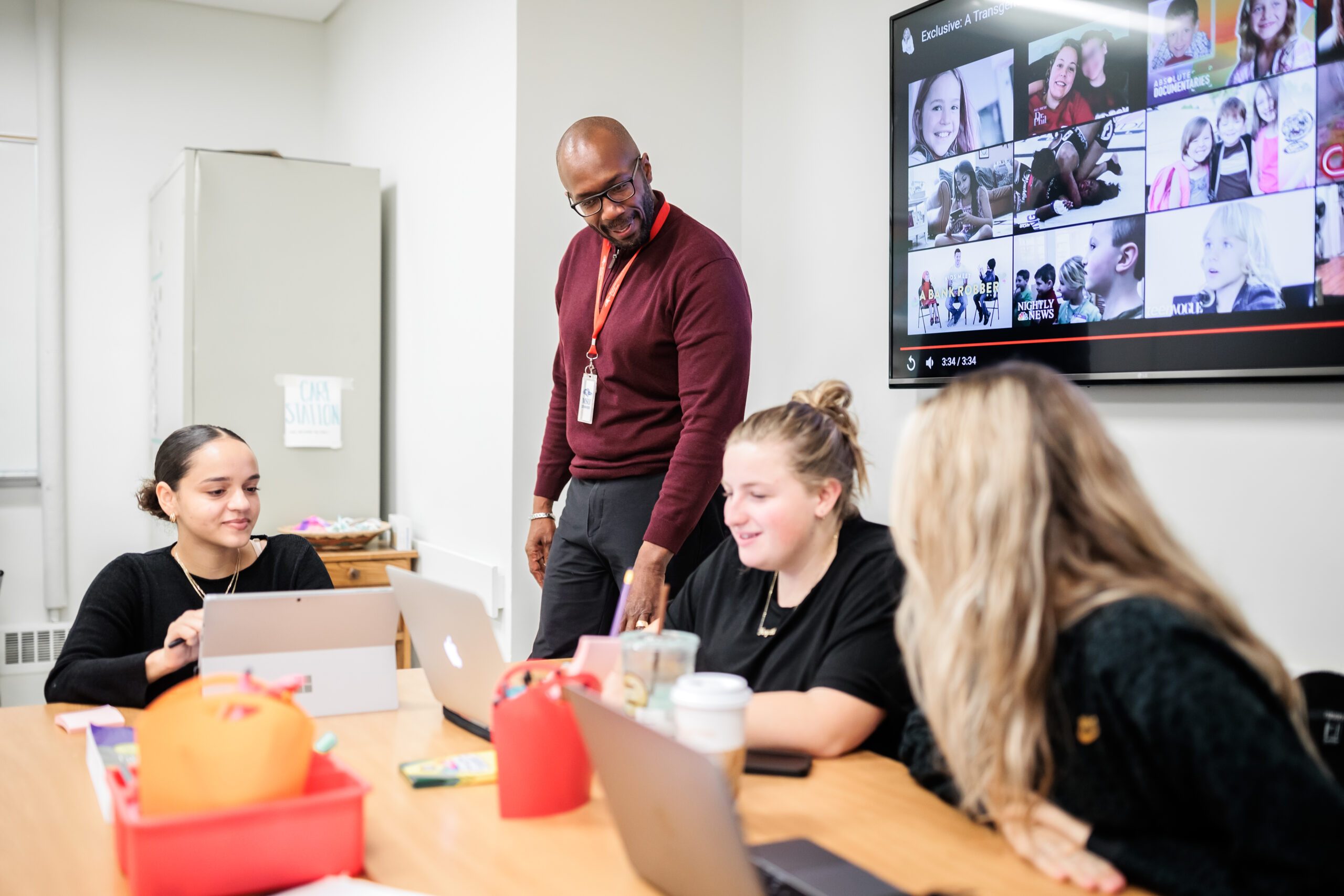 Group of people in a room looking at a computer screen
