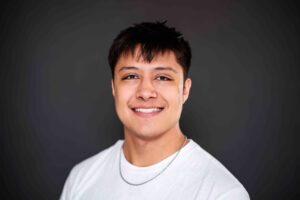 headshot of Alex with white shirt and black background