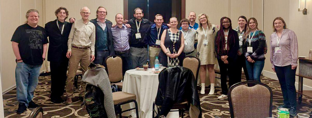 Several alumni pose for the camera at a party