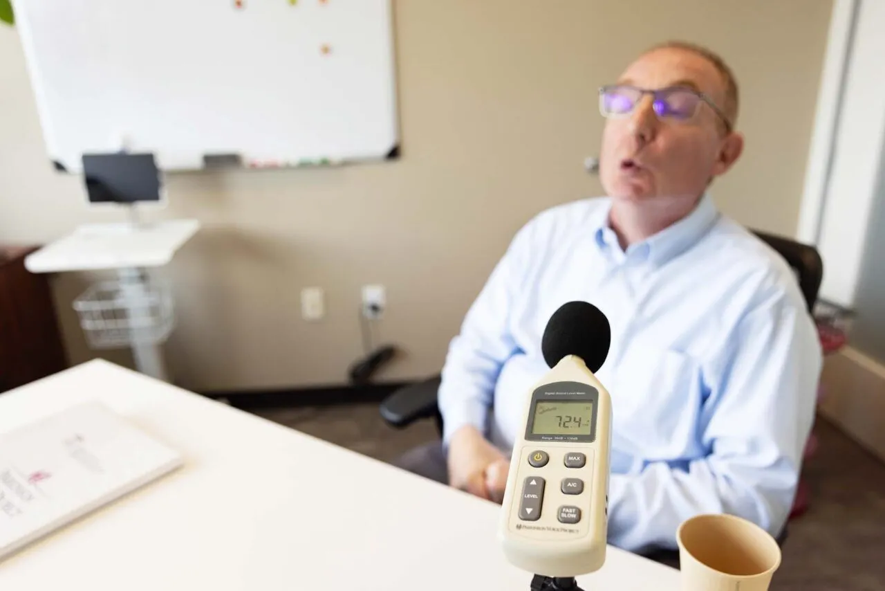 Client that has Parkinson's Disease. There is a microphone in front of the client.