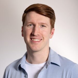 Headshot of person in blue button up and white shirt.