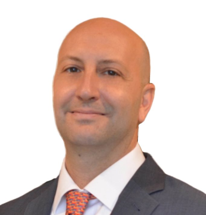 A headshot of Jason Howard wearing a black suit and red tie in front of a white background.