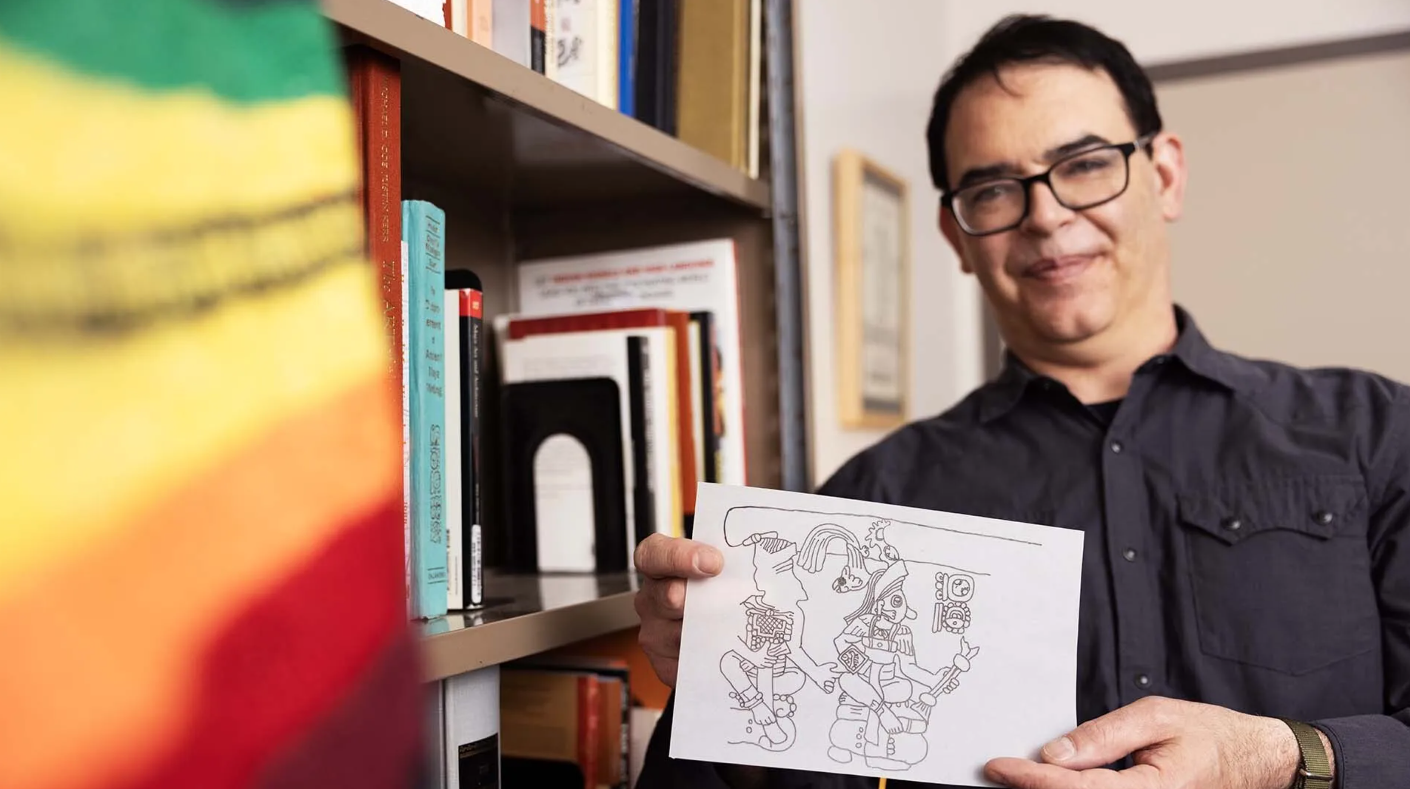 Associate Professor Richard Sandoval, Ph.D., holds an epigraphic line drawing that he created based on his research.