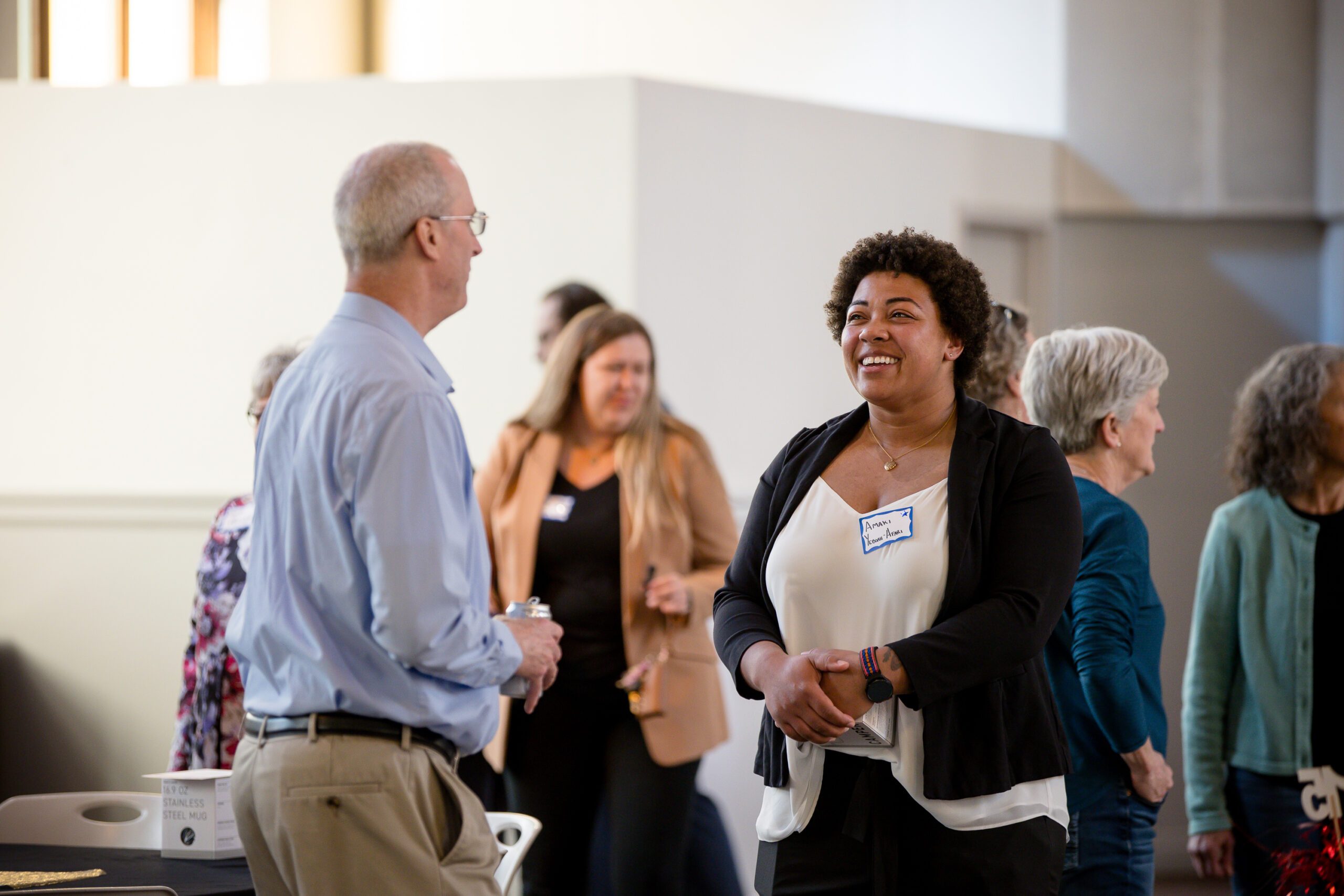 photo of faculty & current student talking in the midst of a crowd at the beginning of MPAcc's 15 year anniversary event