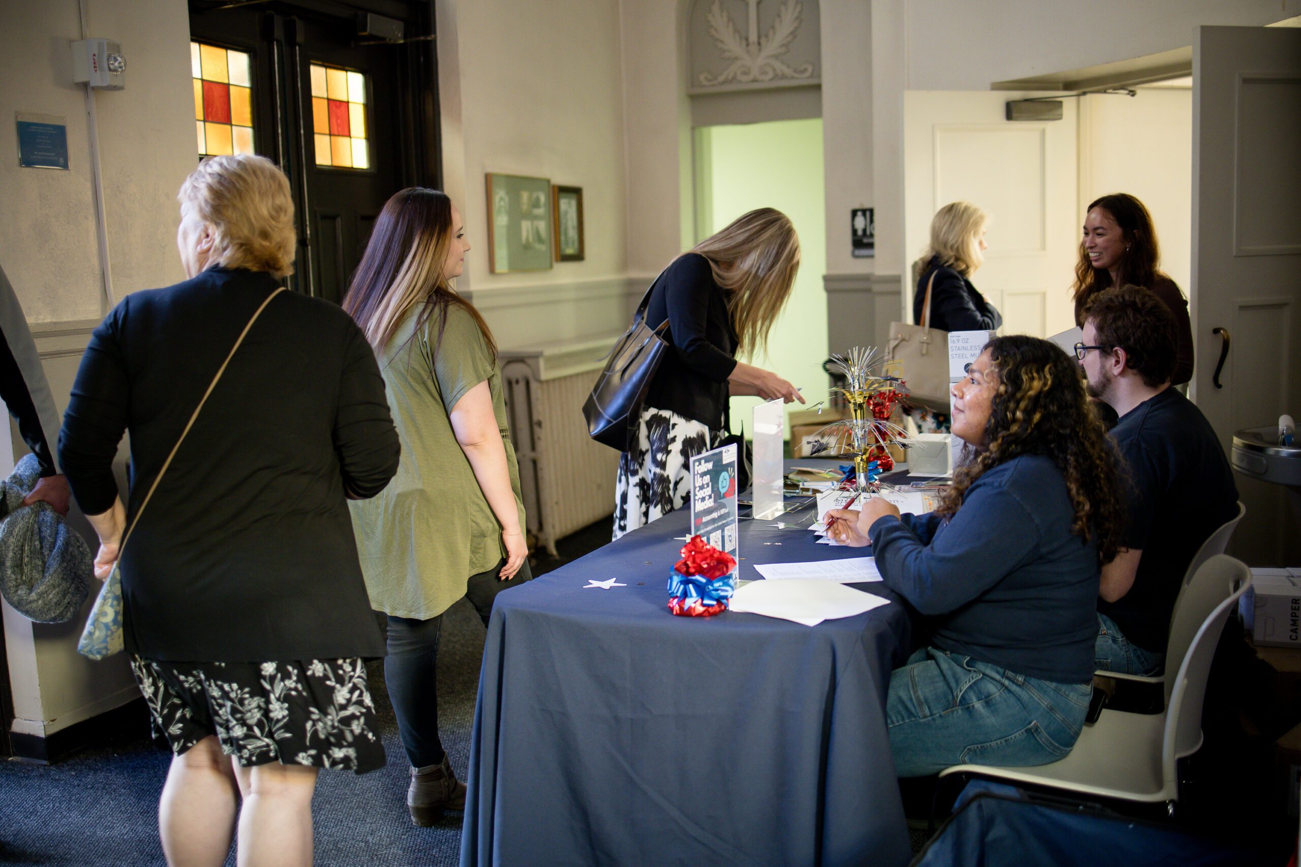 faculty and alum checking in at MPAcc's 15 year anniversary event, with ASO officers running check in at a decorated table