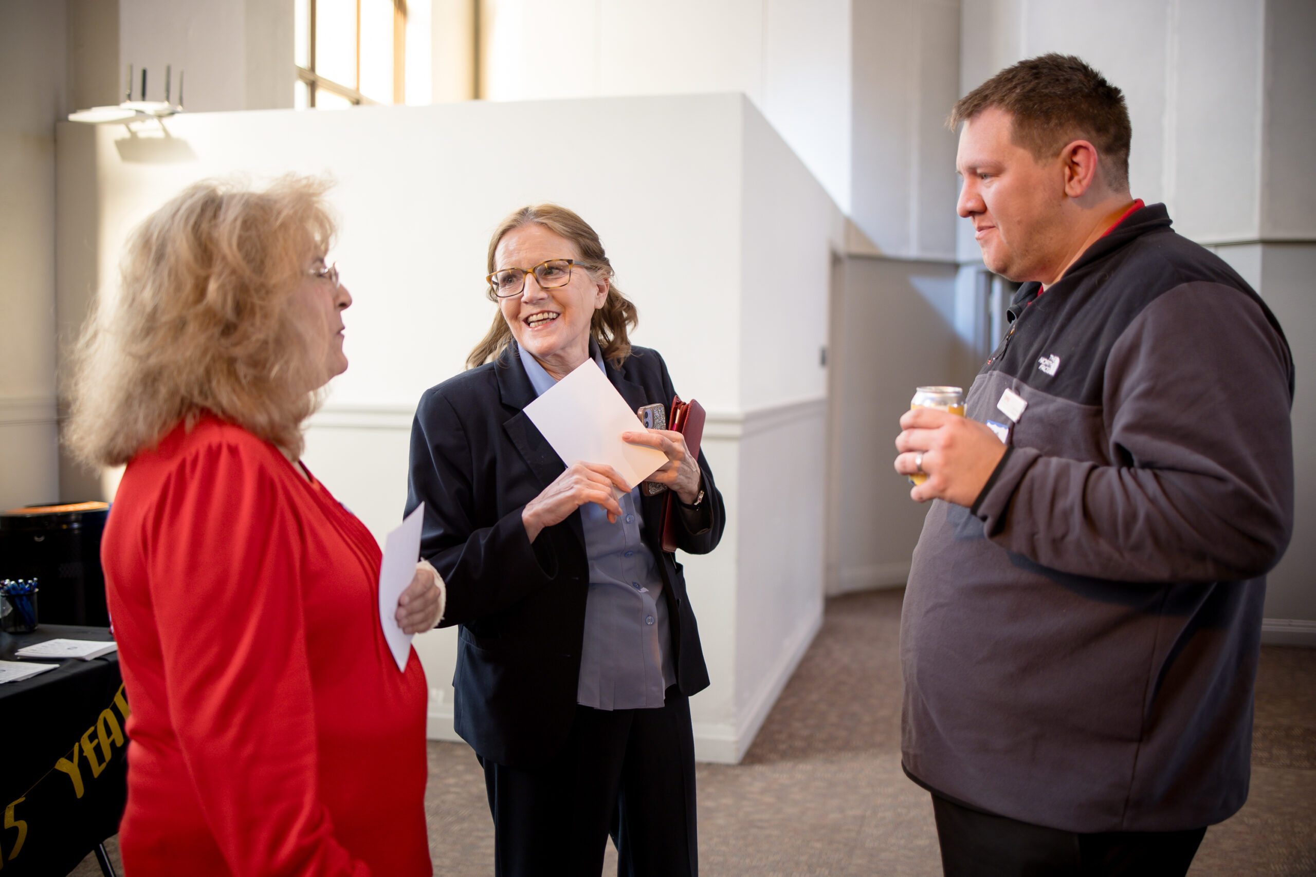 3 attendees talking at the beginning of the event - MPAcc's 15 year anniversary