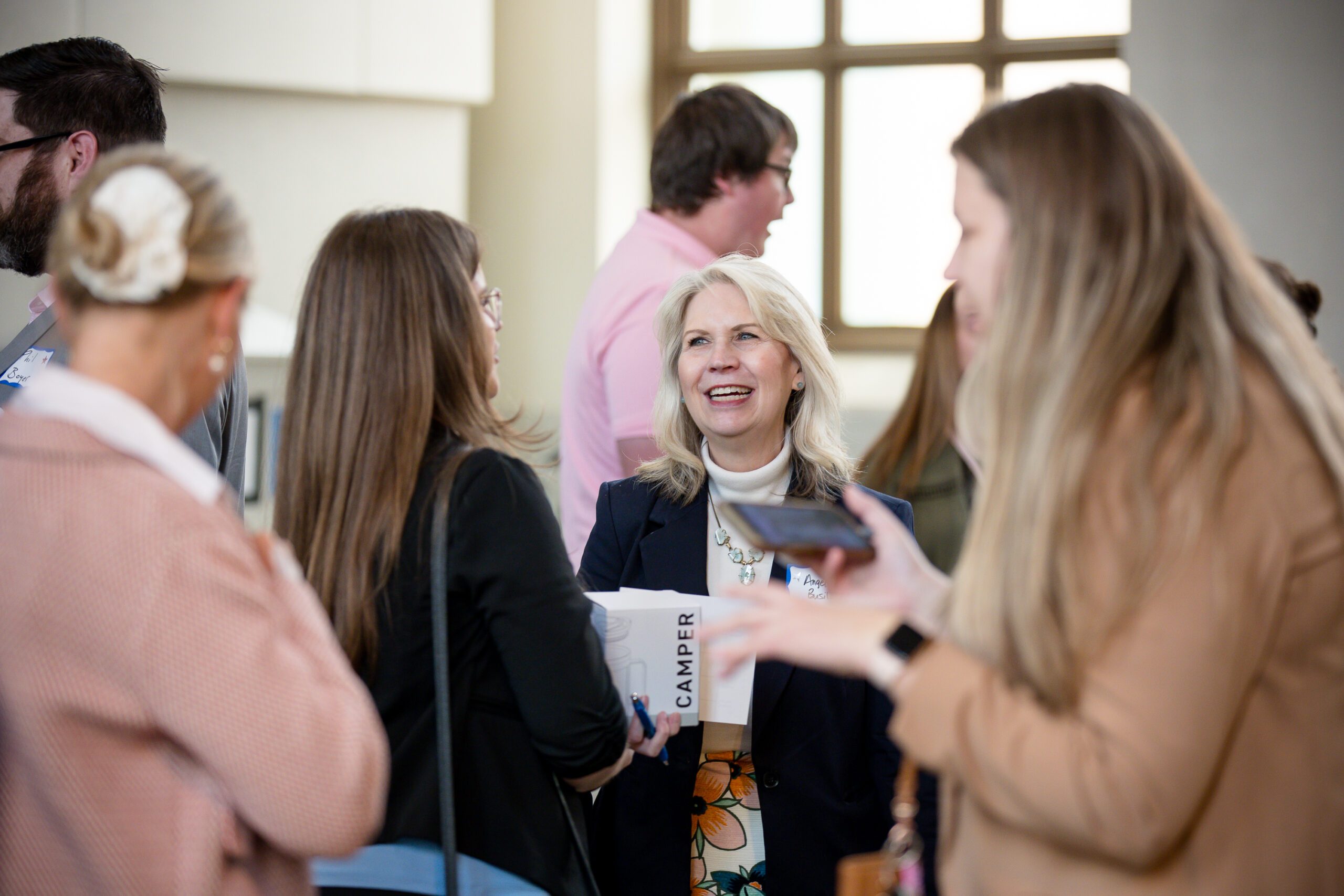 candid photo of faculty and alumni talking in the beginning of MPAcc's 15 year anniversary event