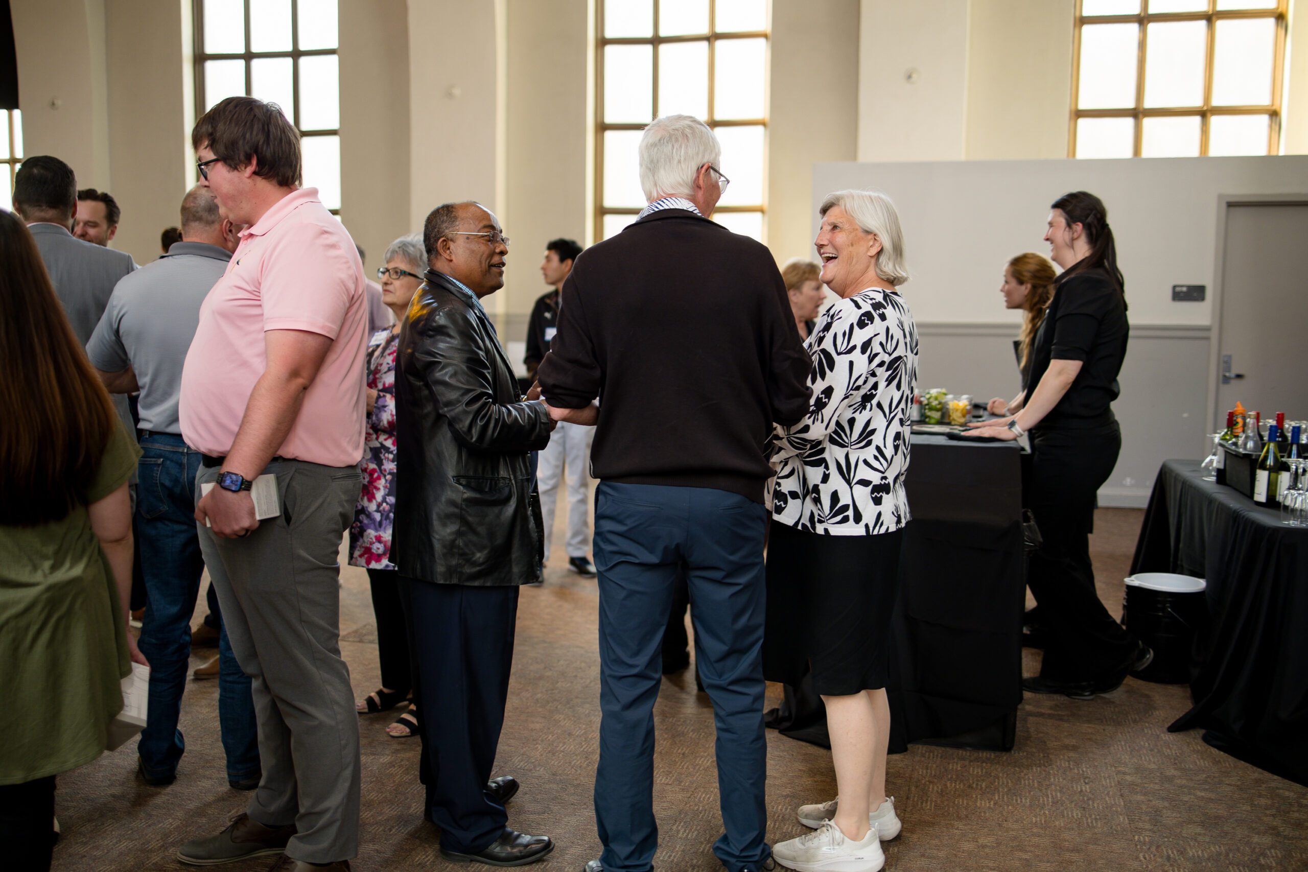 candid photo of various faculty, leadership, and alumni socializing in the beginning of MPAcc's 15 year anniversary event
