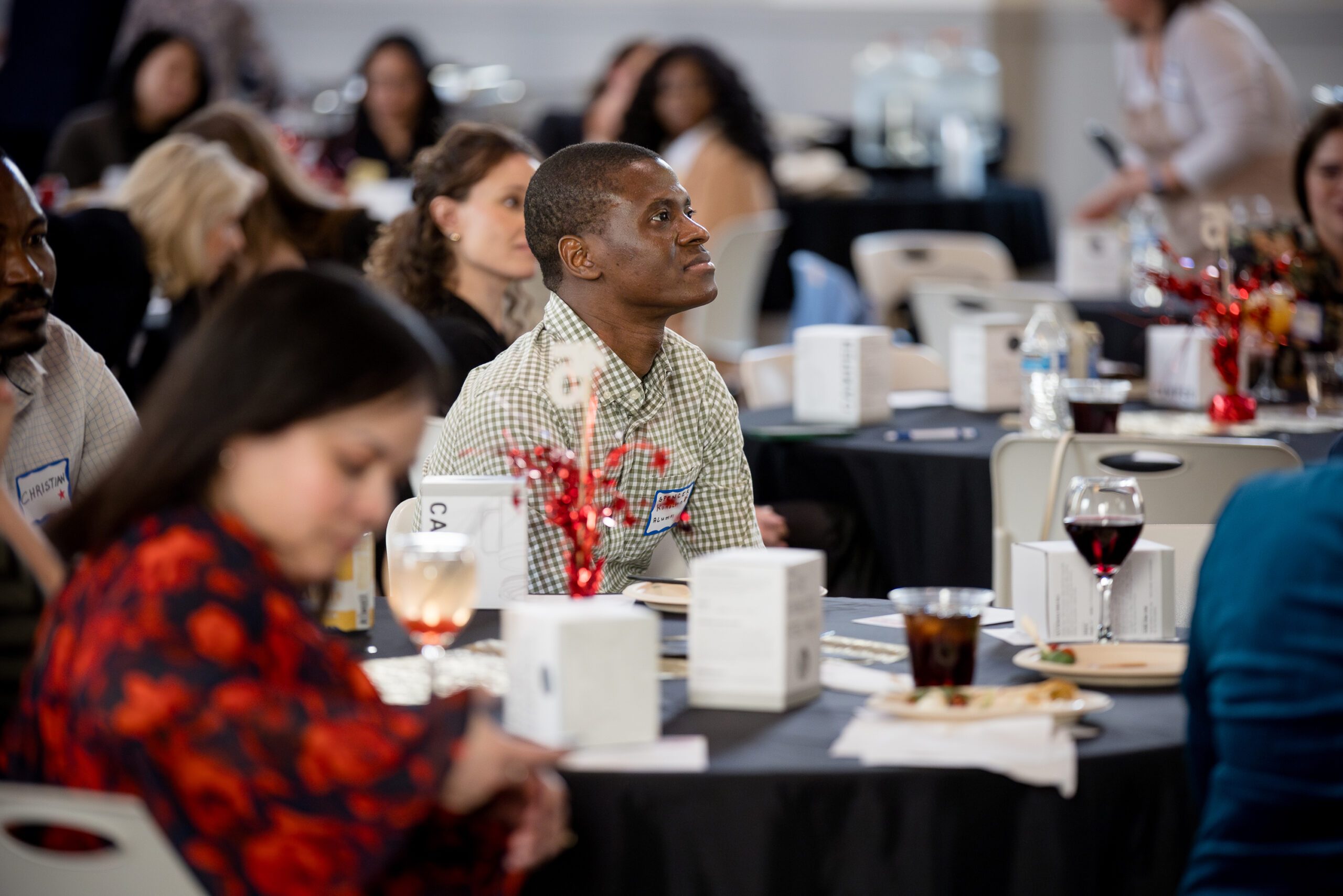MPAcc's 15 year anniversary event - close up of an alumni table in the audience watching speaker