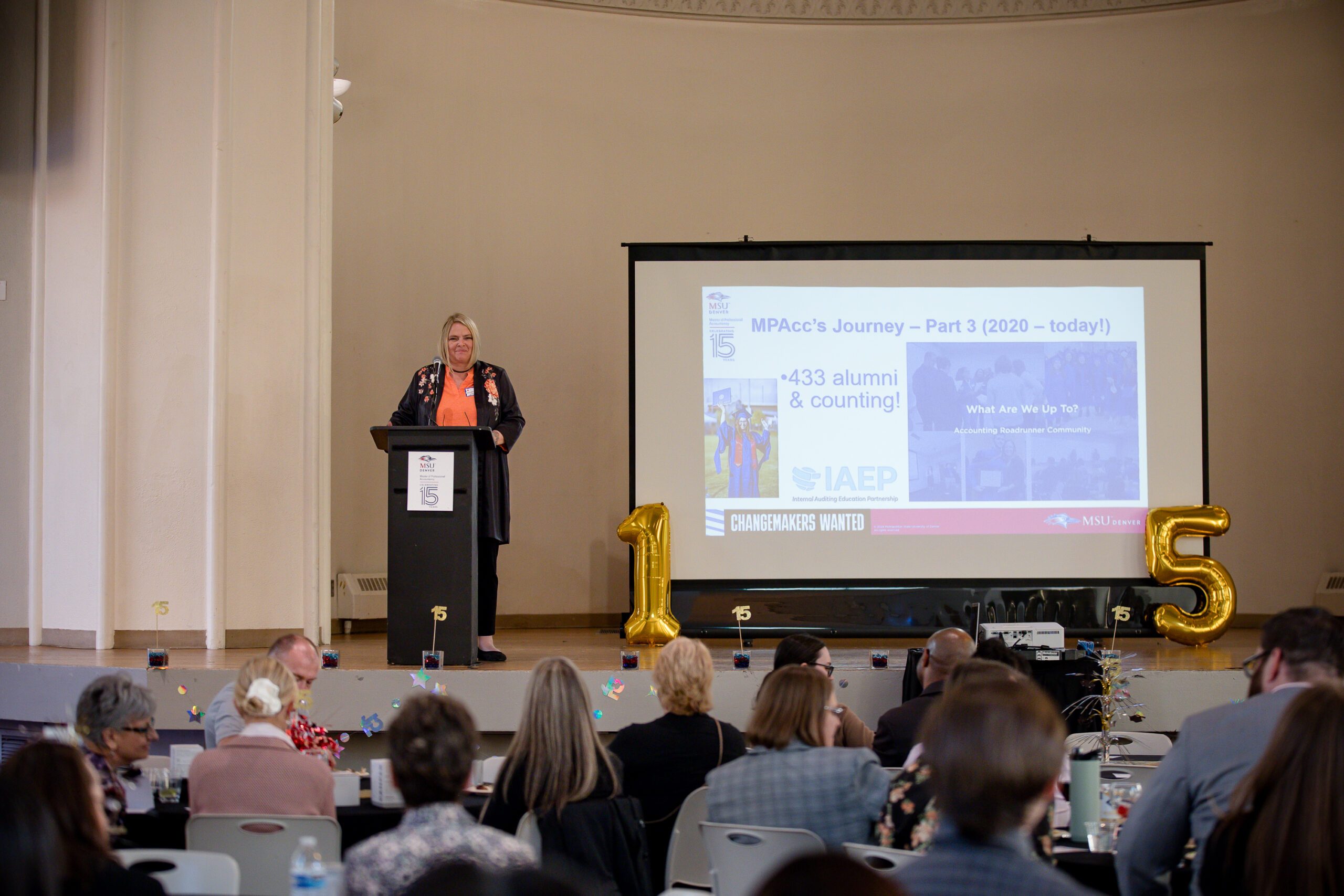 MPAcc's 15 year anniversary event - Dr. Kristina Kesselring talking at the podium in front of a crowded room