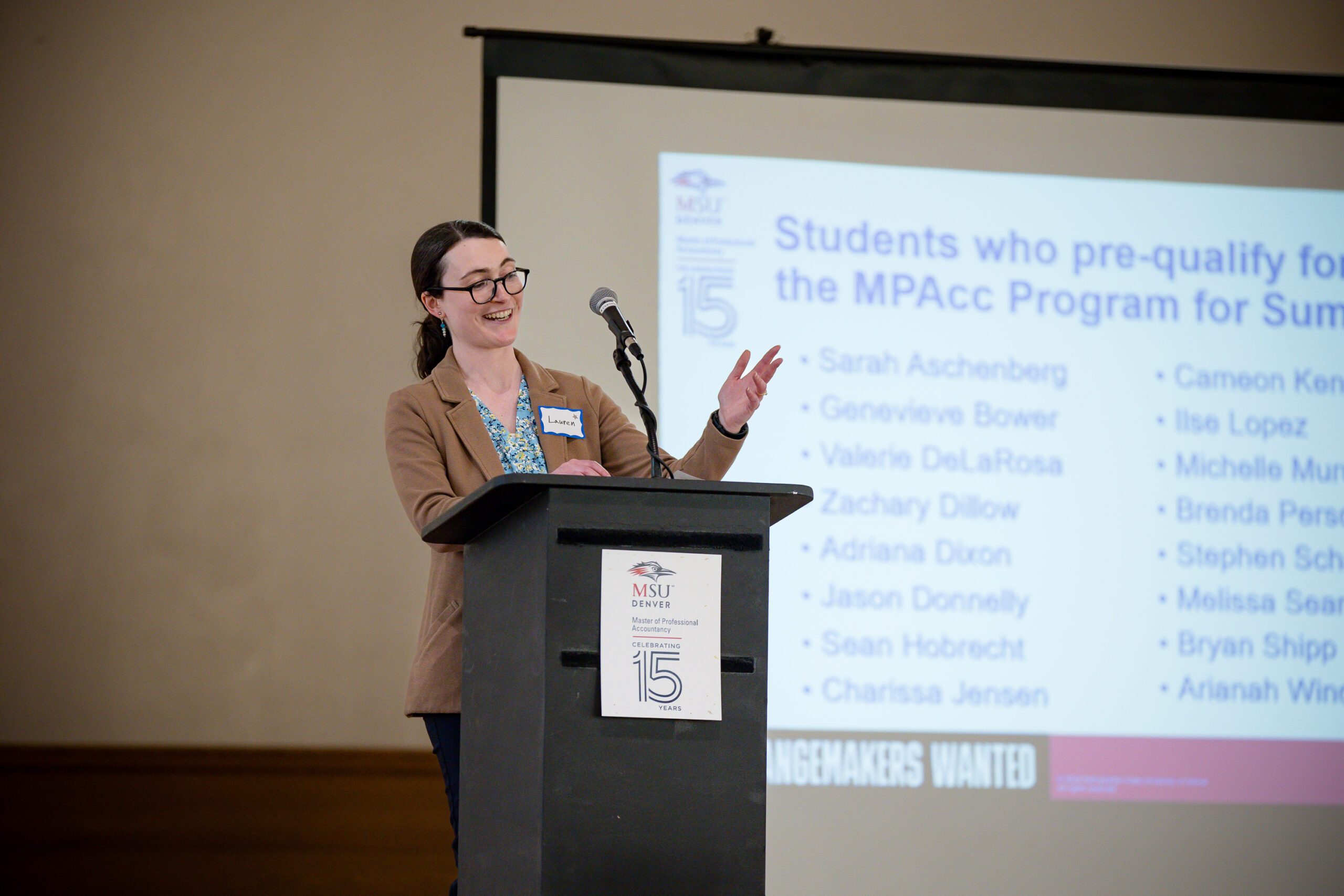 MPAcc's 15 year anniversary event - Lauren Shaffer at the podium in front of ppt slide