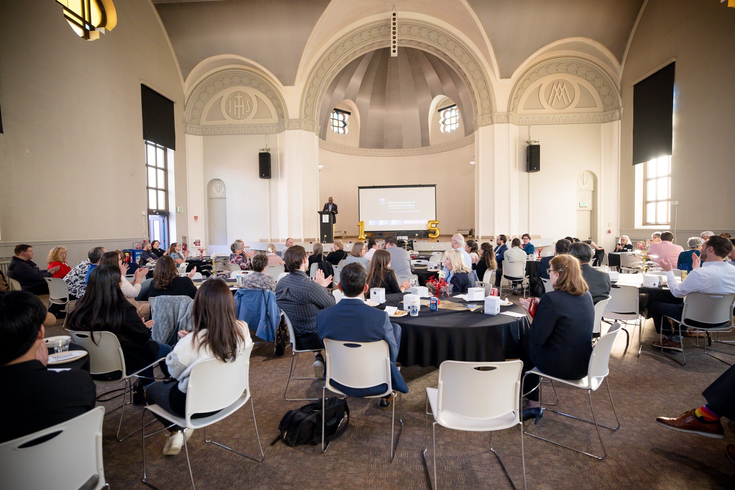 MPAcc's 15 year anniversary - full room, photo taken front back of room looking at stage