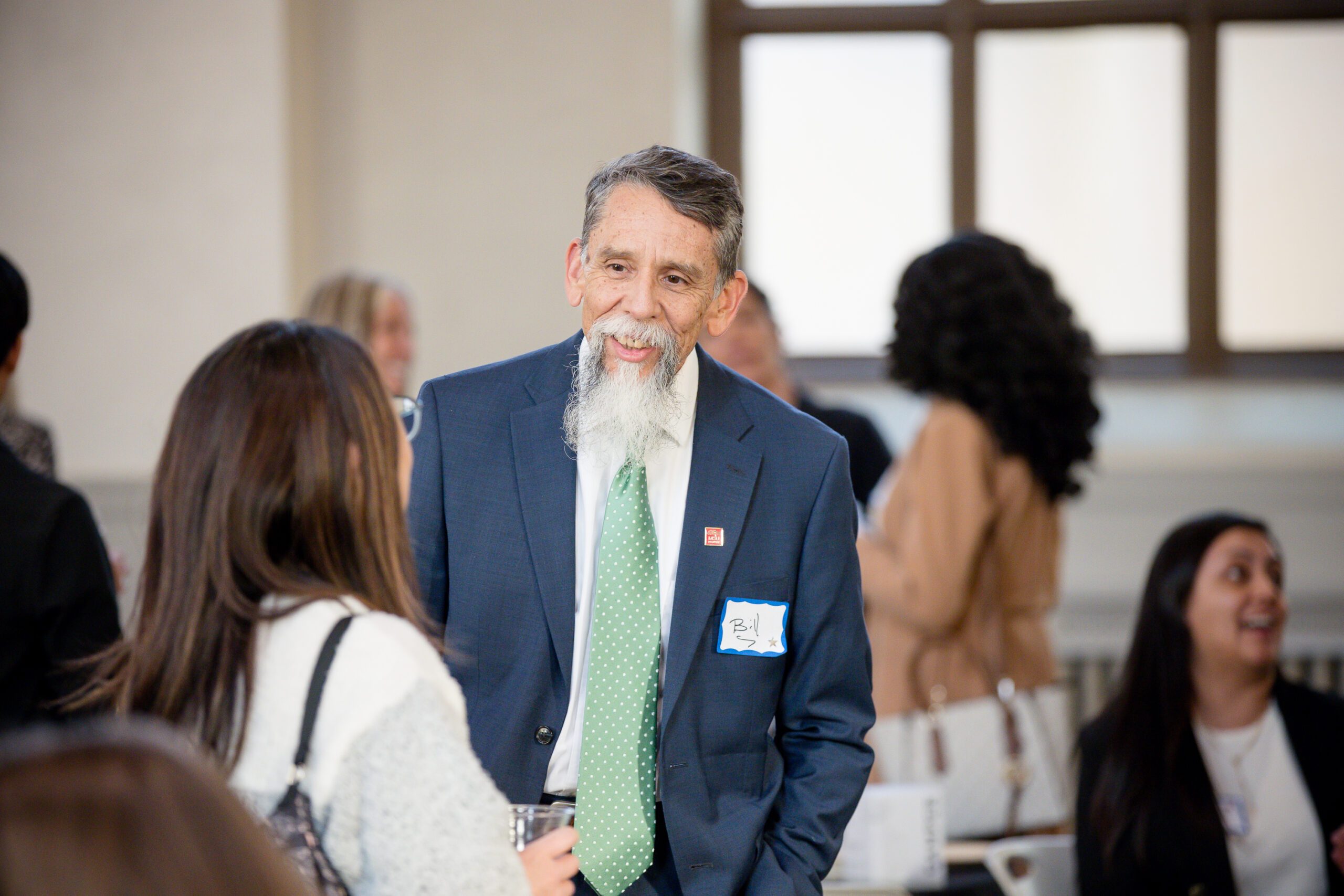 MPAcc's 15 year anniversary event - candid photo of professor Bill Mesa talking with alum