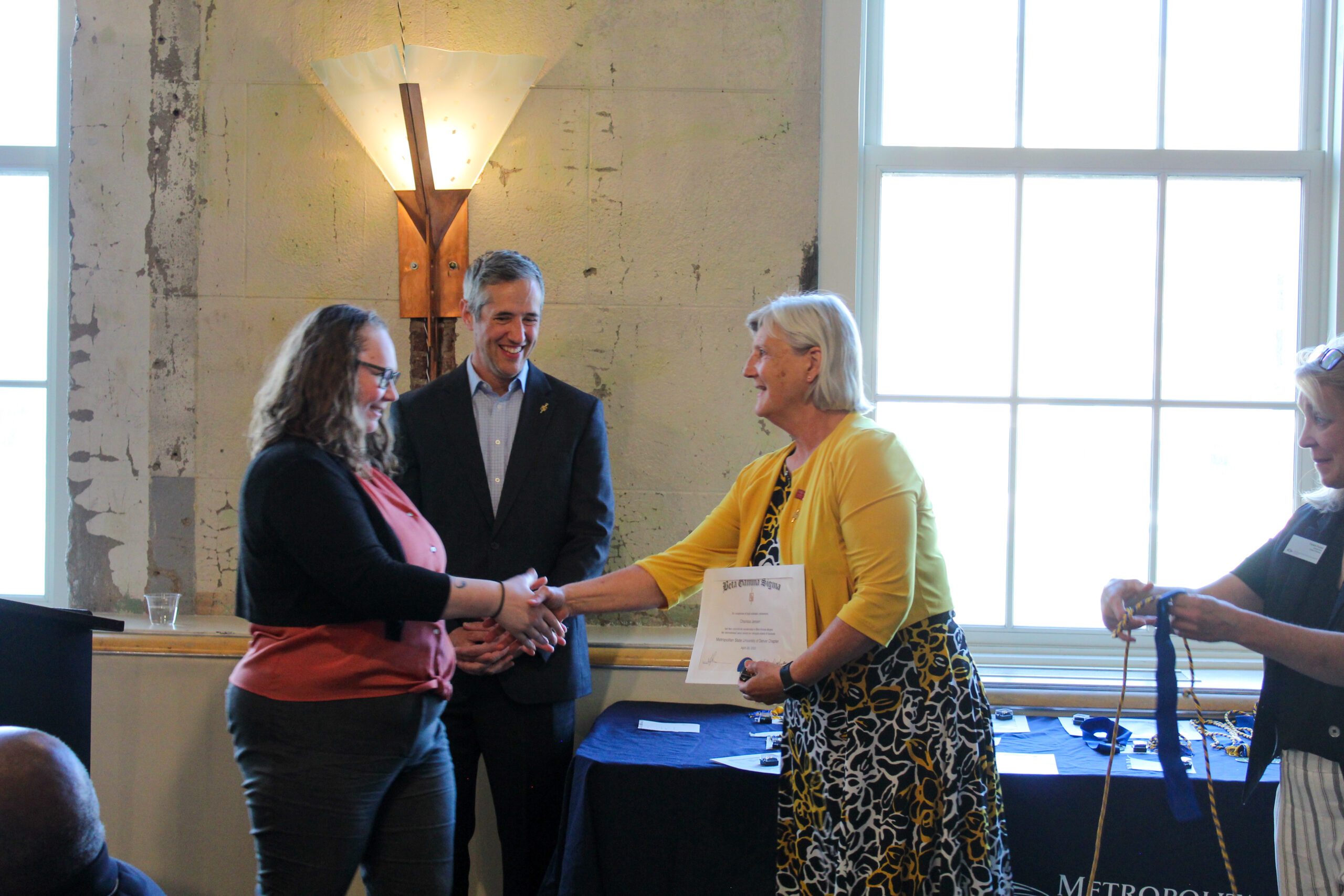 Dean Ann Murphy shaking hands with Charissa, MSU Denver Student