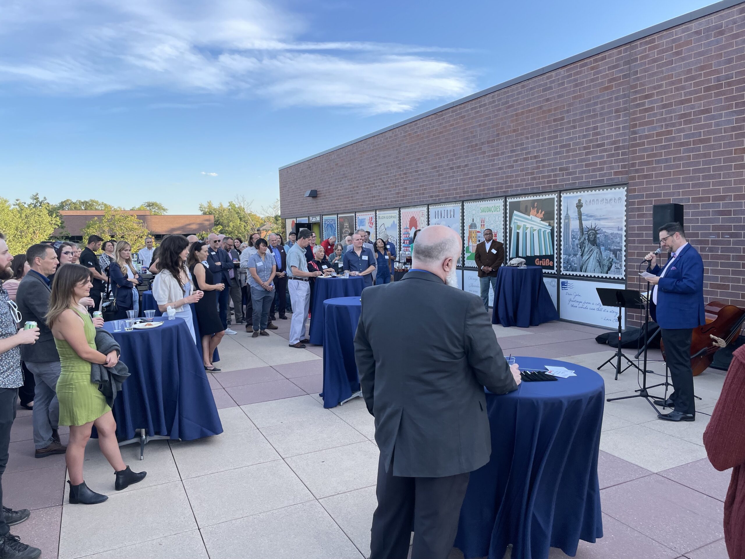 Guests stand at tables hearing Dean Masserini speak