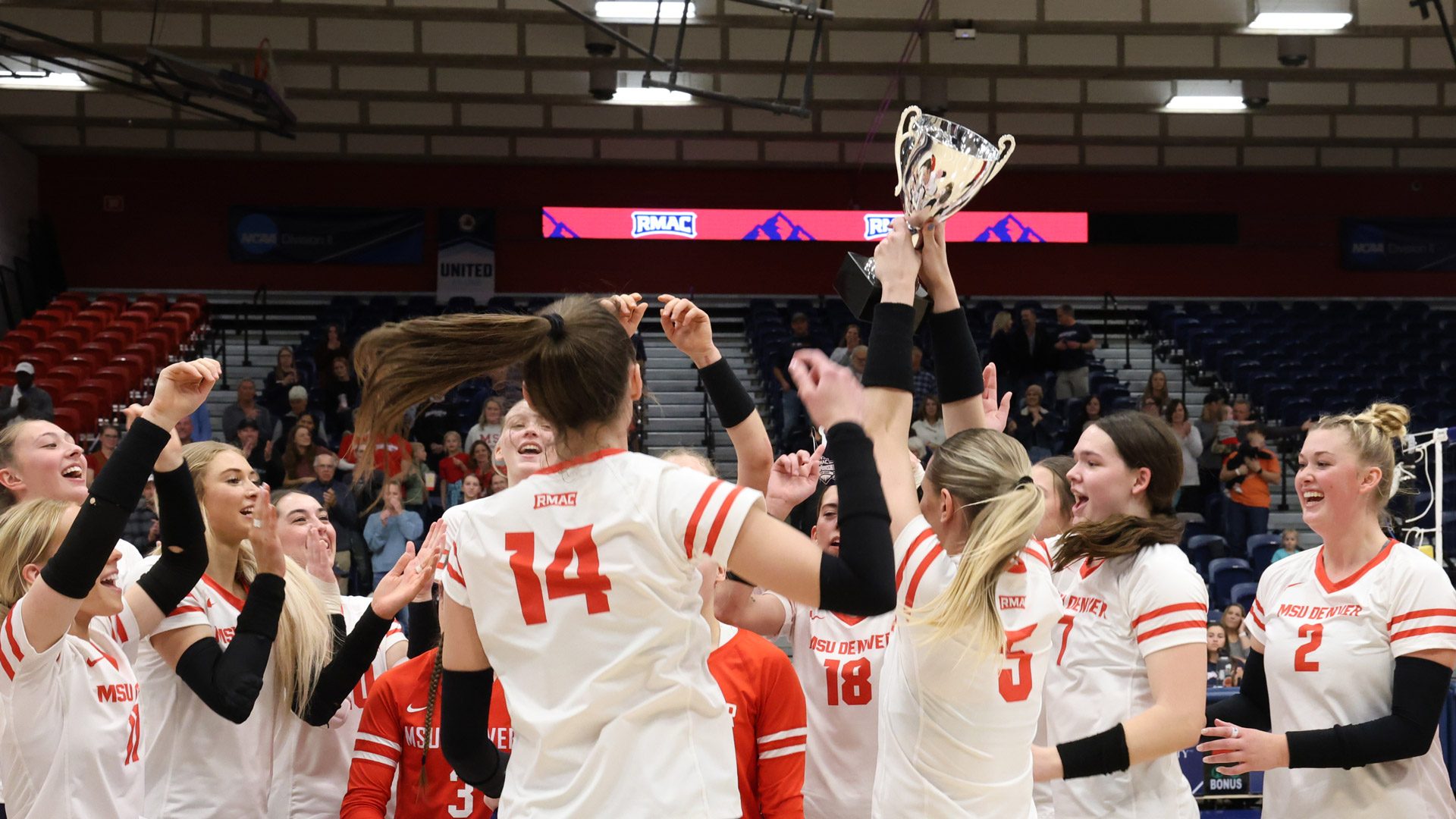 MSU Denver's volleyball team celebrates with the RMAC championship trophy at the 2024 conference tournament
