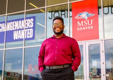 2025 MSU Denver graduate Chrisnel Akele standing in front of JSSB on campus