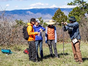 MSU Denver student Jonathan Lee, right, collects a soil sample with a soil probe at the site where native Rainbow Scarab Beetles are due to be released at Daniels Park in Sedalia, Col. Photo by Alyson McClaran