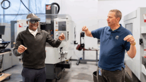 MSU Denver student Faisal Kaweesa and instructor Stephen Morgan use augmented reality headsets to practice precision measurement skills in a training simulation.