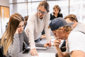 teacher helping students in a classroom