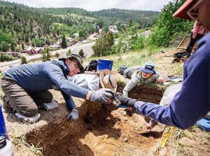 MSU Denver Anthropology student Jeremy Davis receives an artifact found in the dig site in Central City. Photo by Alyson McClaran