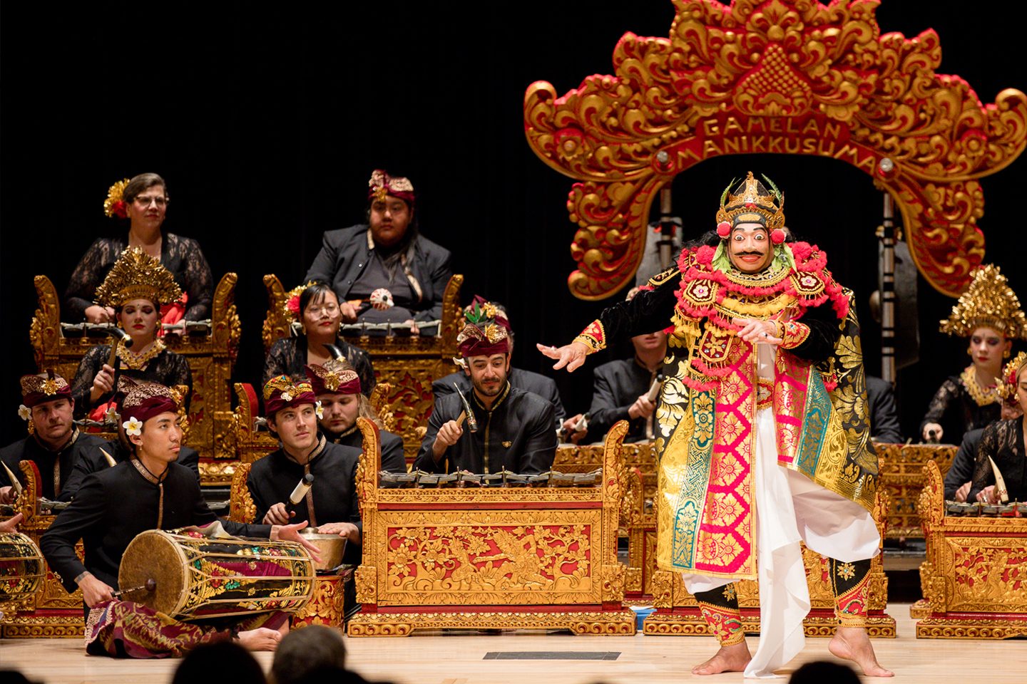 Gamelan instruments and dancers with masks on stage